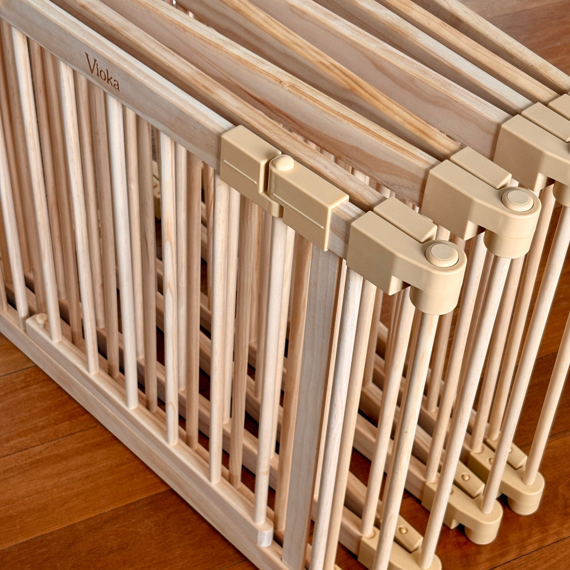Beige baby gate on a wooden floor